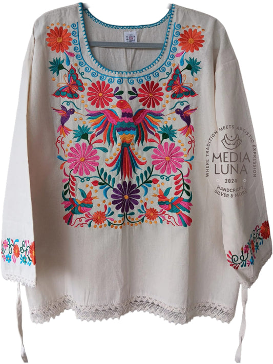 Blusa artesanal con bordado de pájaros y flores.